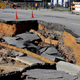Workers block a road damaged by floodwaters caused by rain from Hurricane Matthew in Fayetteville, N.C., Sunday, Oct. 9, 2016. Hurricane Matthew’s torrential rains triggered severe flooding in North Carolina on Sunday as the deteriorating storm made its exit to the sea, and thousands of people had to be rescued from their homes and cars. (Image: AP)